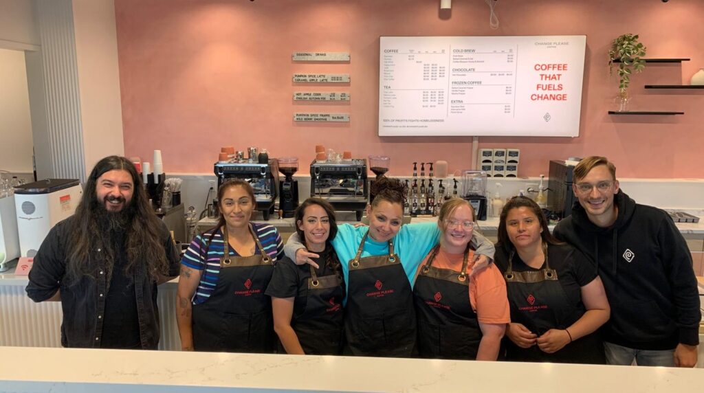 Change Please team behind a counter