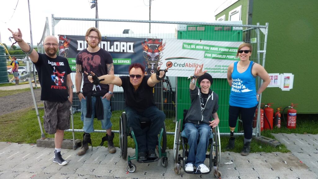A group of people in front of a sign from Download Festival