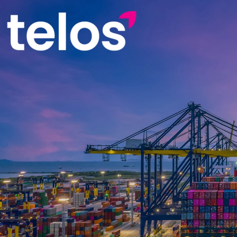The telos logo above a pink tinged sky below which is a crane and shipping containers